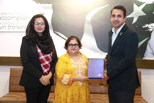 Ms. Hiba presenting a souvenir to Superior University representatives